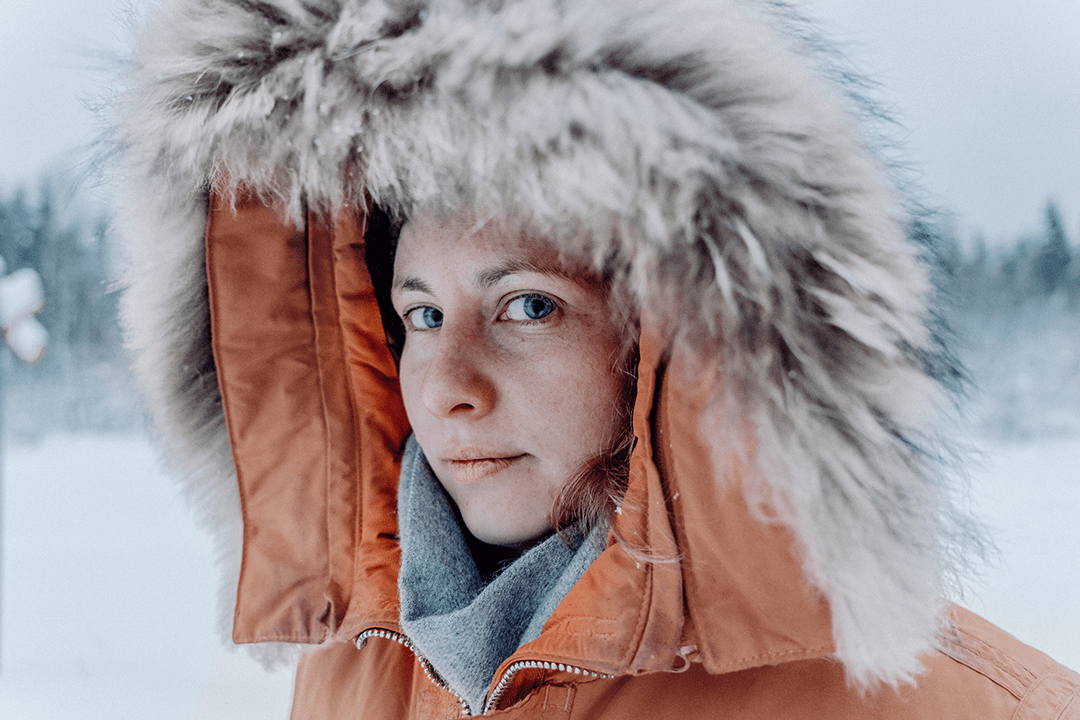 close up of woman wearing parka on a snowy winter day